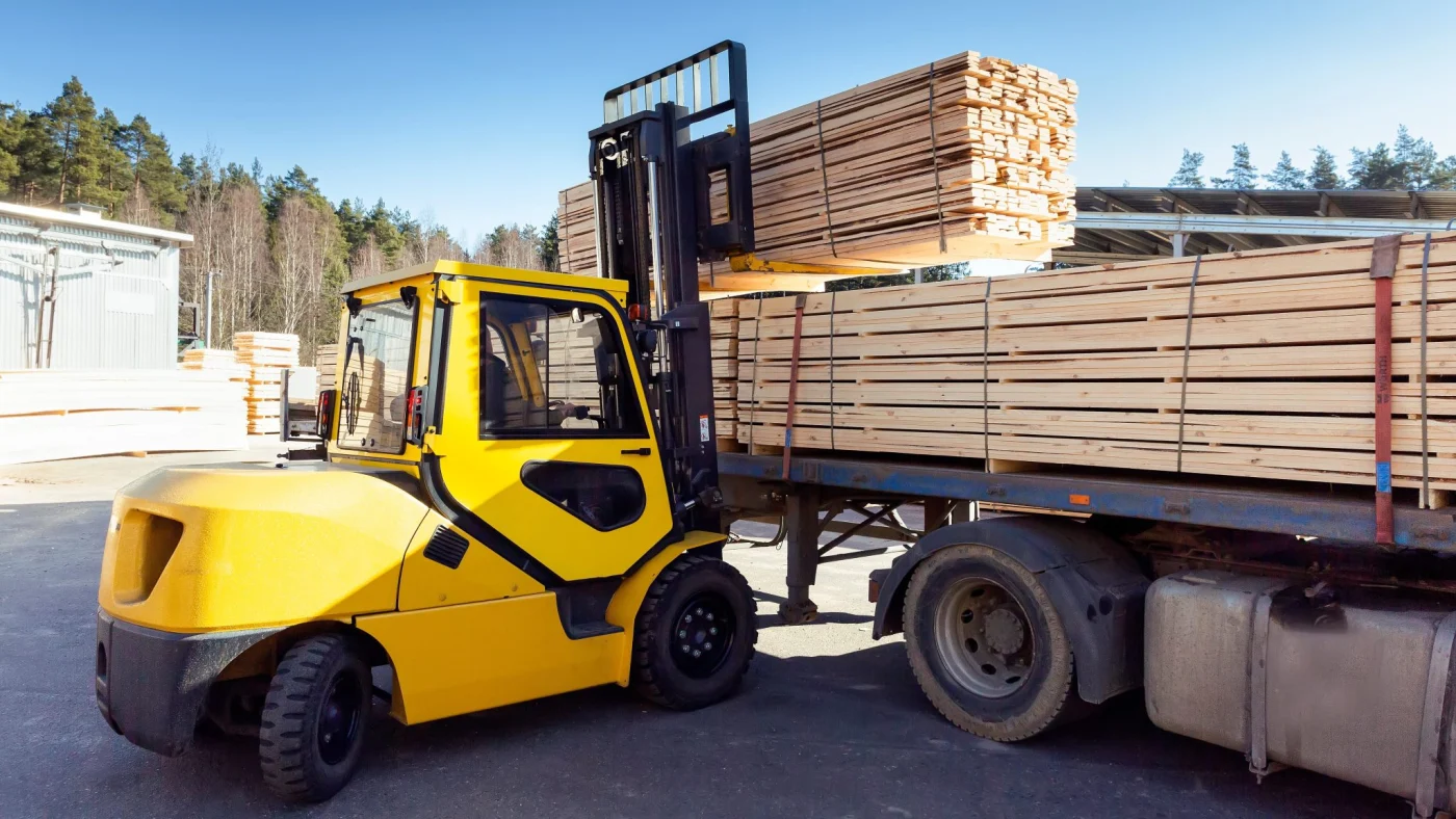 Forklift unloading lumber from delivery truck