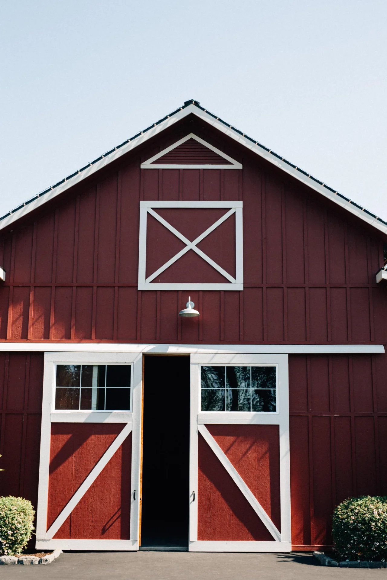 Dependable Barndominium In Des Moines, IA | North Country Truss Two barndominiums in a grassy field beside a pond.